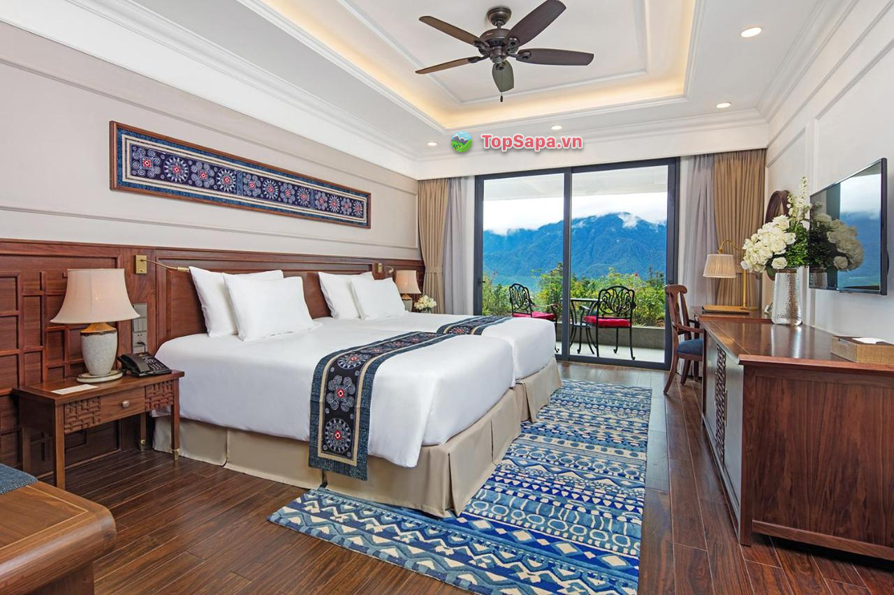 Phòng nghỉ với sàn được lót gỗ, nội thất bằng gỗ cao cấp, giường nệm và họa tiết trang trí sử dụng đồ thổ cẩm mang